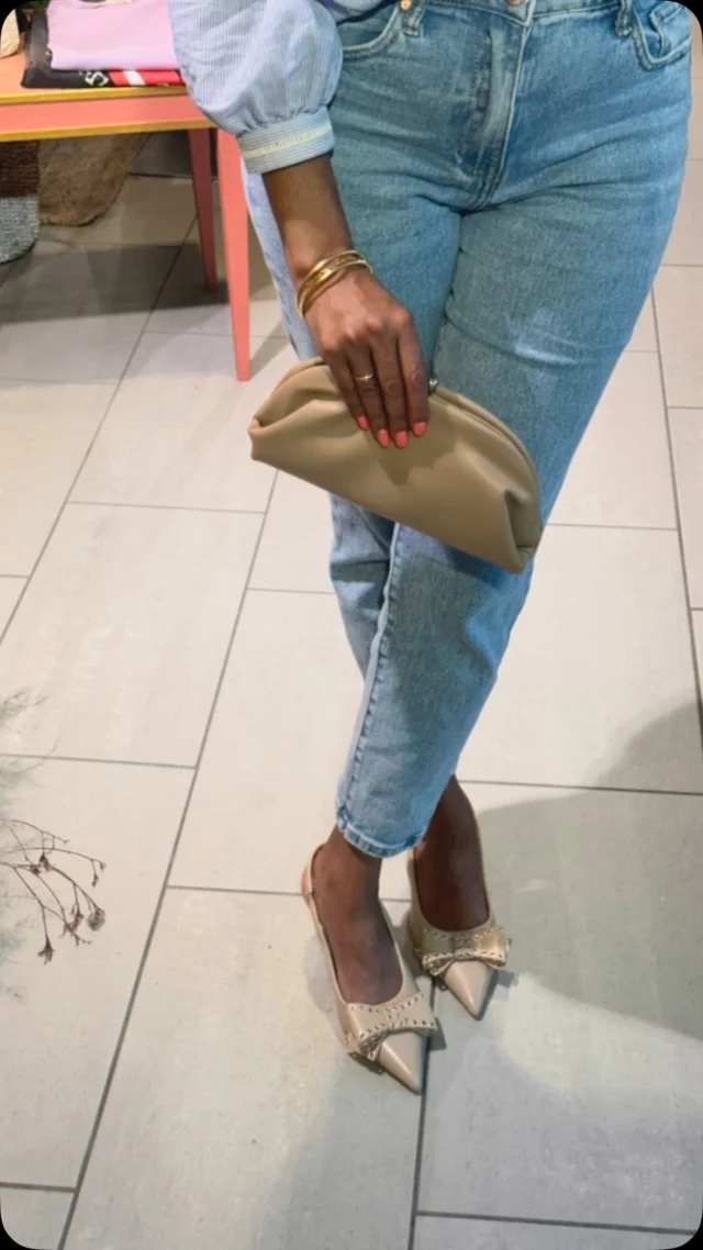 Ces chaussures sont vraiment élégantes et stylées ! Le design pointu leur donne une touche sophistiquée, et le nœud orné de clous dorés ajoute une belle dose de caractère et de glamour. La couleur nude est parfaite : elle allonge la jambe et se marie facilement avec plein de tenues. Portées avec un jean mum comme ici, ça crée un contraste chic et décontracté très réussi.